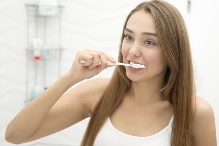Mujer cuidando su salud oral - ¿SON REALMENTE EFICACES LAS PASTAS DE DIENTES BLANQUEADORAS? - Dentista en Avilés